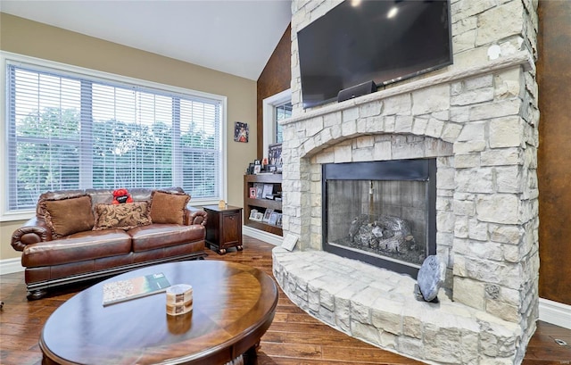 living room featuring dark hardwood / wood-style flooring, a fireplace, and vaulted ceiling