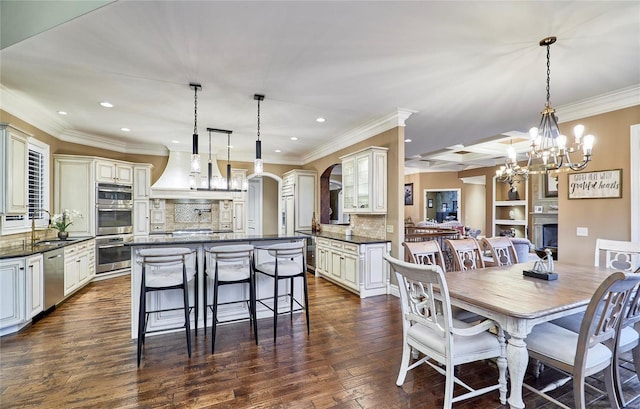 dining space featuring ornamental molding, dark hardwood / wood-style floors, and sink