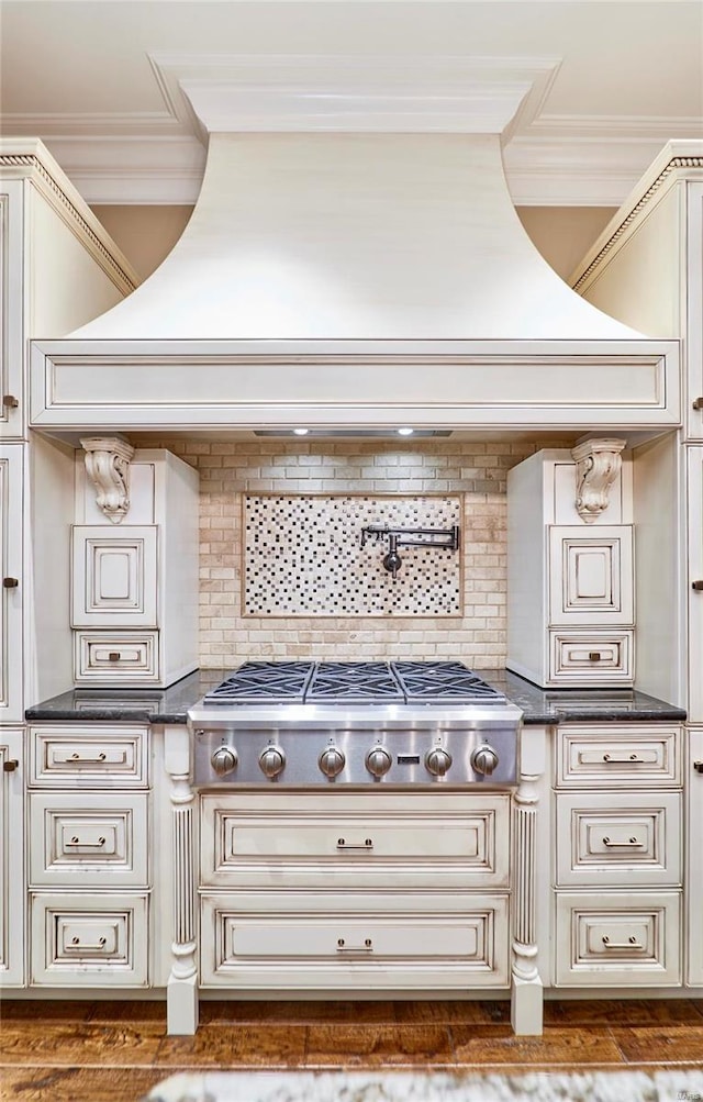 details featuring crown molding, decorative backsplash, and stainless steel gas stovetop