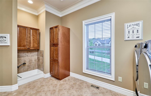 bathroom with crown molding, washing machine and clothes dryer, and tile patterned floors