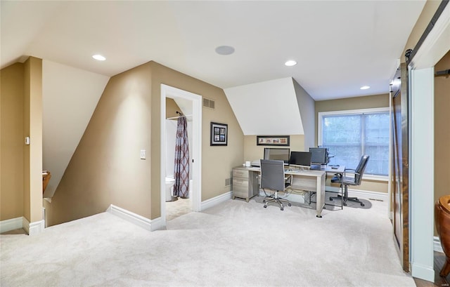 office area featuring a barn door and light carpet