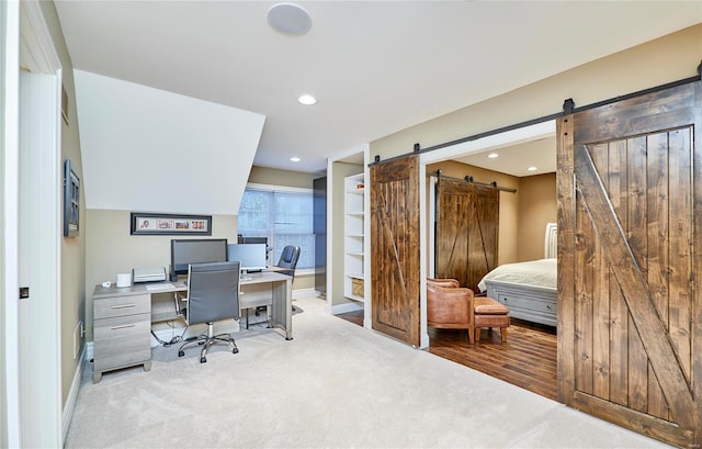 office space featuring a barn door and light colored carpet