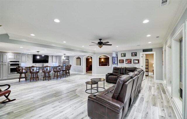 living room featuring crown molding, light hardwood / wood-style flooring, and ceiling fan