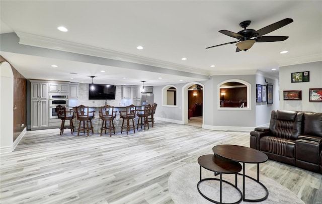 living room with crown molding, ceiling fan, and light hardwood / wood-style floors