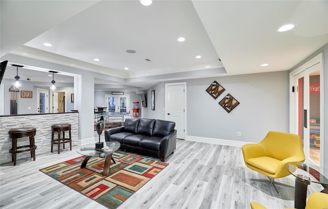 living room featuring light hardwood / wood-style floors and a raised ceiling