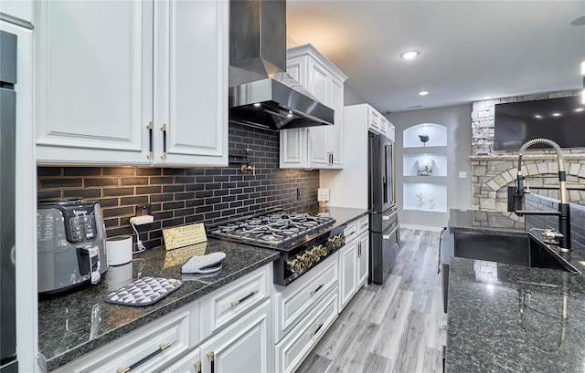 kitchen with extractor fan, sink, white cabinets, dark stone counters, and stainless steel gas cooktop