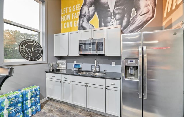 kitchen featuring dark stone countertops, sink, stainless steel appliances, and white cabinets