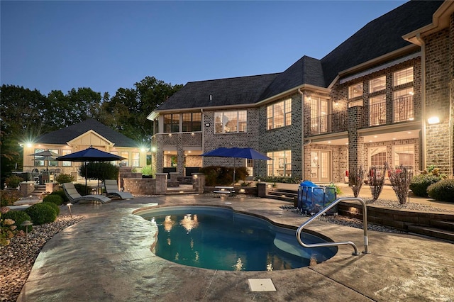 pool at dusk featuring a patio area