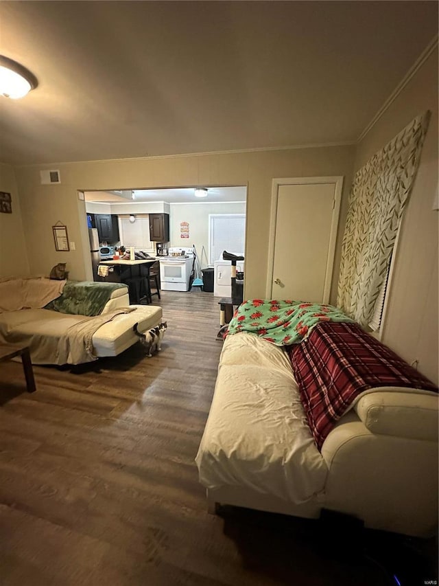 bedroom featuring crown molding, dark hardwood / wood-style floors, and stainless steel refrigerator