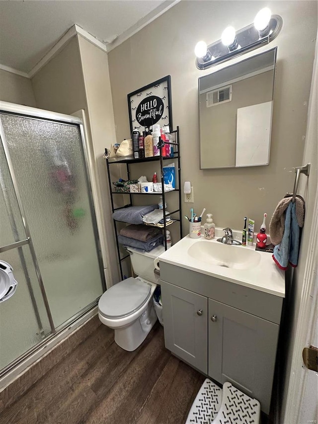 bathroom featuring a shower with door, wood-type flooring, ornamental molding, and vanity