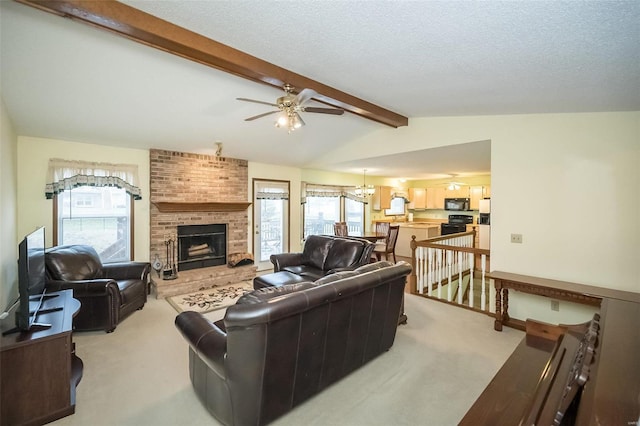 living room featuring ceiling fan with notable chandelier, lofted ceiling with beams, a brick fireplace, light carpet, and a textured ceiling