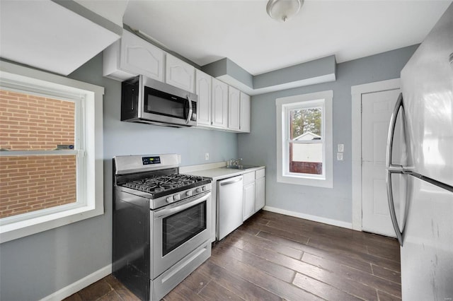 kitchen featuring white cabinetry, appliances with stainless steel finishes, dark hardwood / wood-style floors, and sink