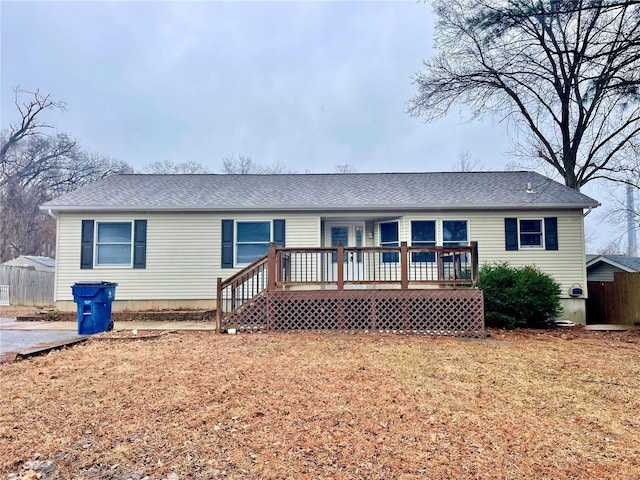 view of front of home with a wooden deck and a front lawn