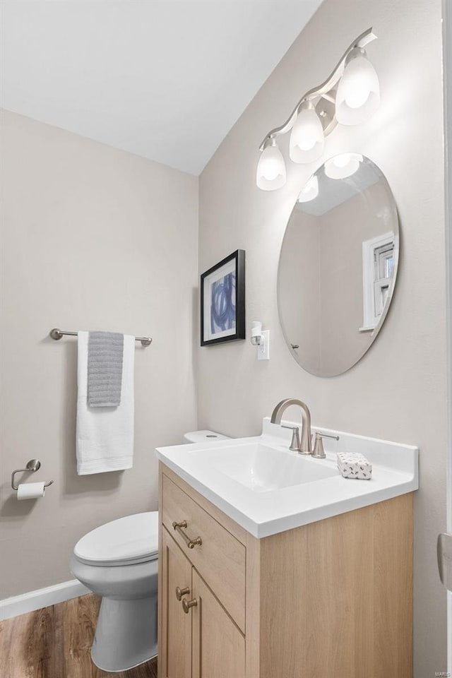 bathroom featuring vanity, toilet, and hardwood / wood-style floors