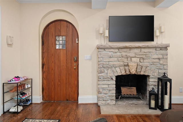 foyer entrance featuring a fireplace and dark hardwood / wood-style flooring