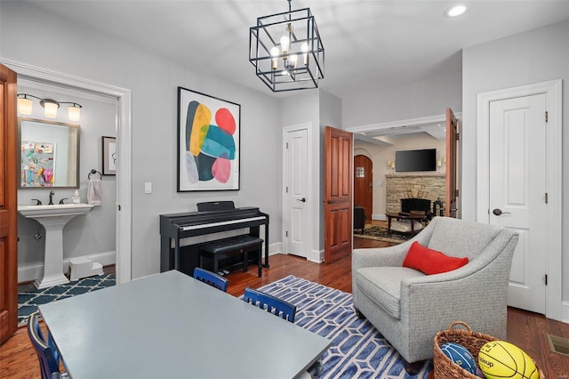 living area featuring a fireplace, dark hardwood / wood-style flooring, and a chandelier