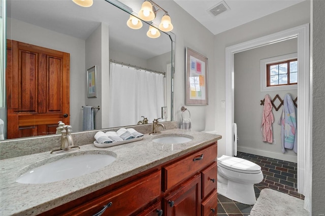 bathroom featuring vanity, tile patterned floors, and toilet