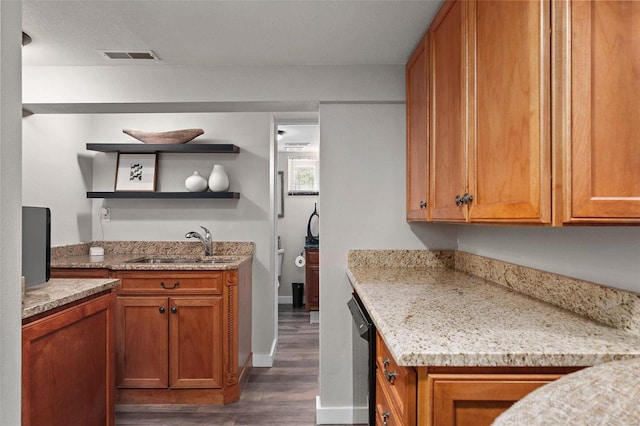 kitchen featuring light stone counters, sink, dark wood-type flooring, and dishwasher