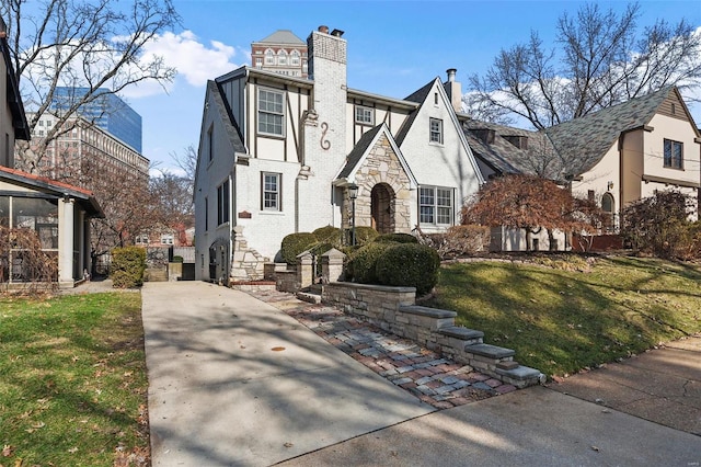 tudor home featuring a front lawn