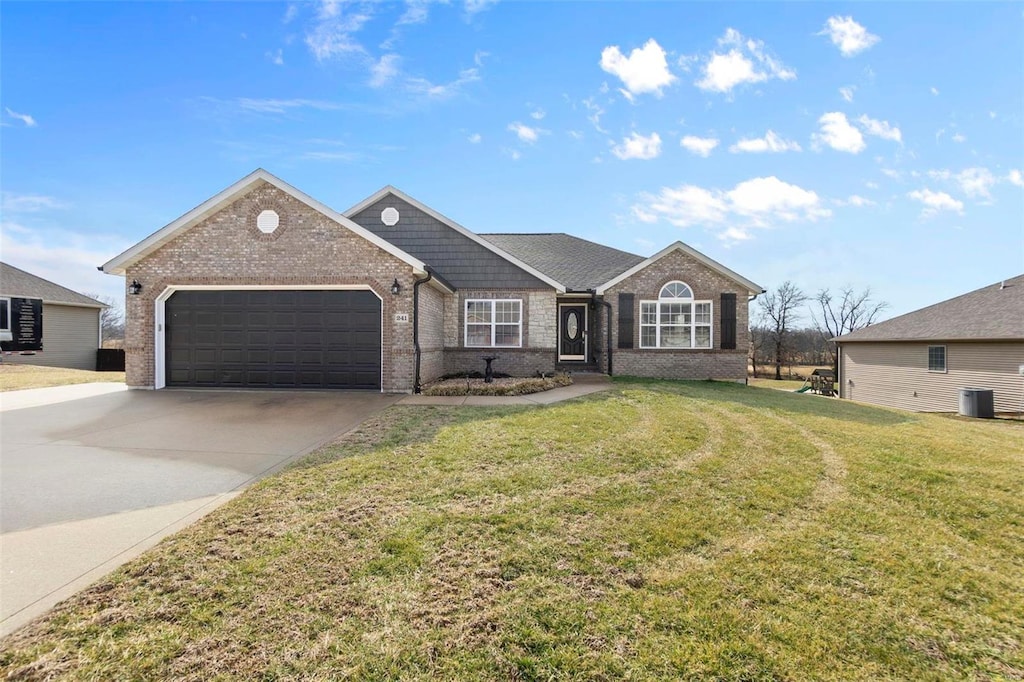 view of front facade with central AC unit, a garage, and a front lawn