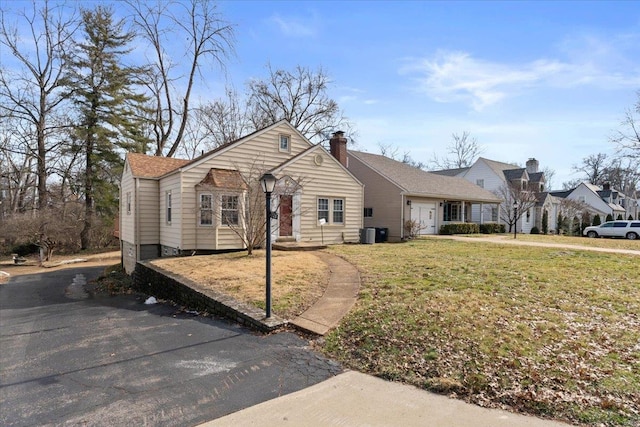 ranch-style house with cooling unit and a front yard