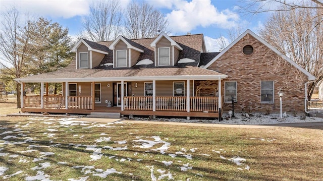 cape cod home with a yard and covered porch