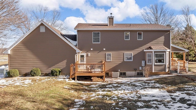 snow covered rear of property with a deck and central air condition unit