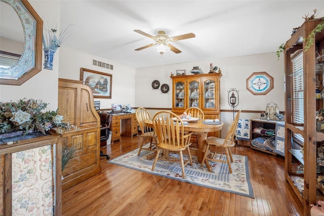 dining area with hardwood / wood-style flooring and ceiling fan