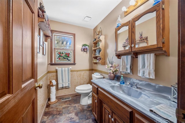 bathroom with vanity, tile walls, and toilet