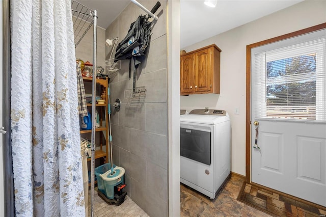 clothes washing area with cabinets and washer / dryer