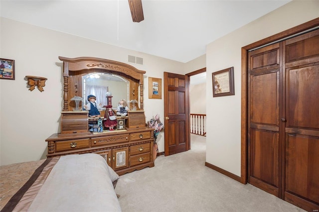 carpeted bedroom featuring ceiling fan and a closet