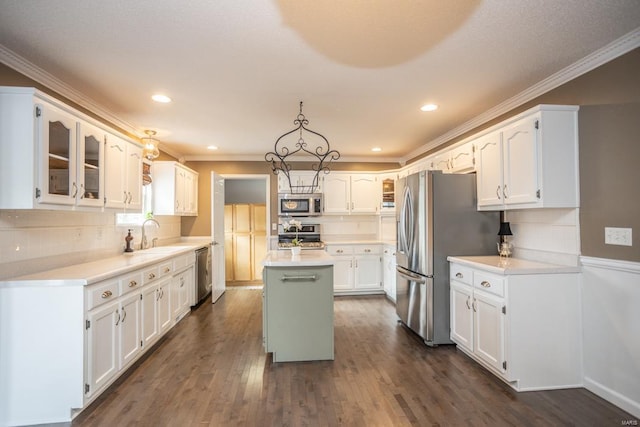 kitchen featuring sink, a center island, hanging light fixtures, stainless steel appliances, and white cabinets