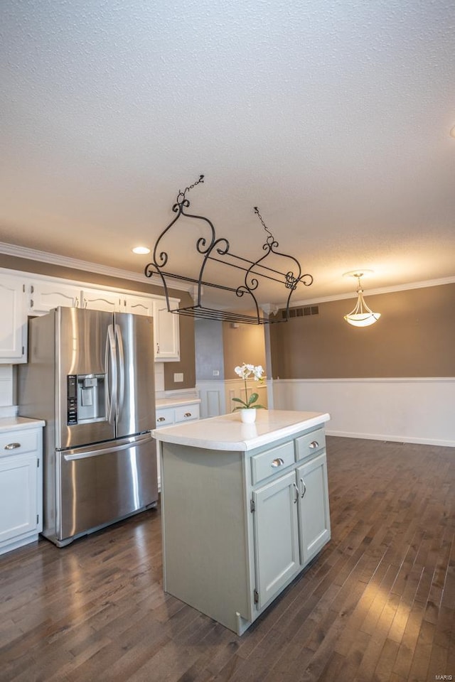 kitchen featuring white cabinetry, stainless steel fridge with ice dispenser, hanging light fixtures, dark hardwood / wood-style flooring, and a kitchen island