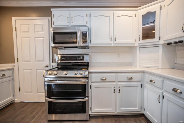 kitchen featuring white cabinetry, stainless steel appliances, dark hardwood / wood-style floors, and backsplash