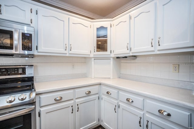 kitchen featuring stainless steel appliances, white cabinets, and backsplash