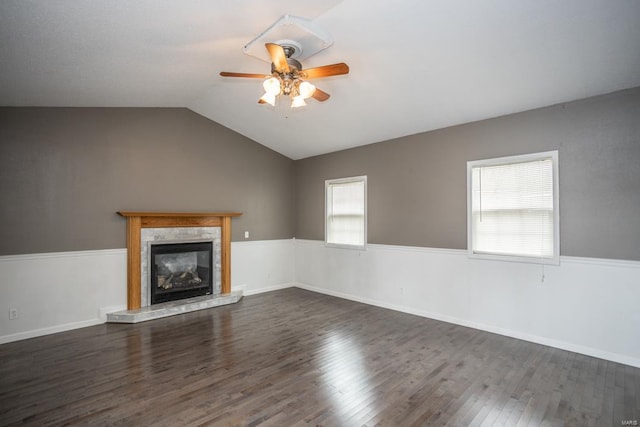 unfurnished living room with dark wood-type flooring, ceiling fan, a tiled fireplace, and vaulted ceiling