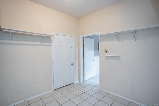 walk in closet with light tile patterned flooring