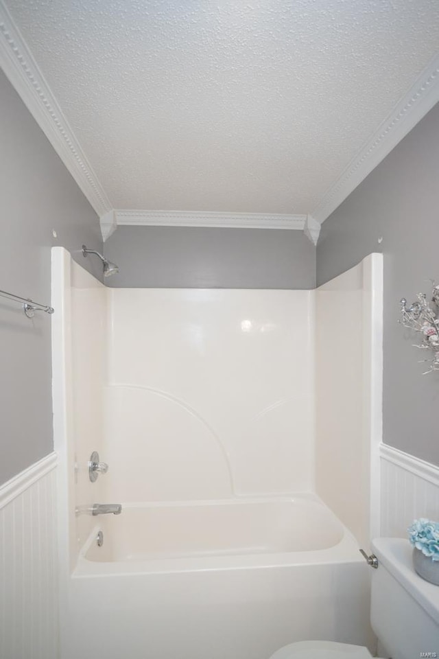 bathroom featuring shower / tub combination, ornamental molding, a textured ceiling, and toilet