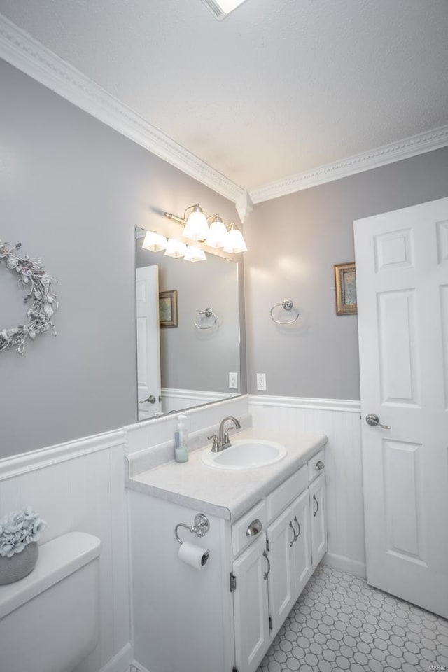 bathroom featuring crown molding, vanity, and toilet