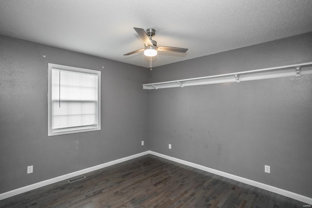 unfurnished room with dark wood-type flooring, ceiling fan, and a textured ceiling