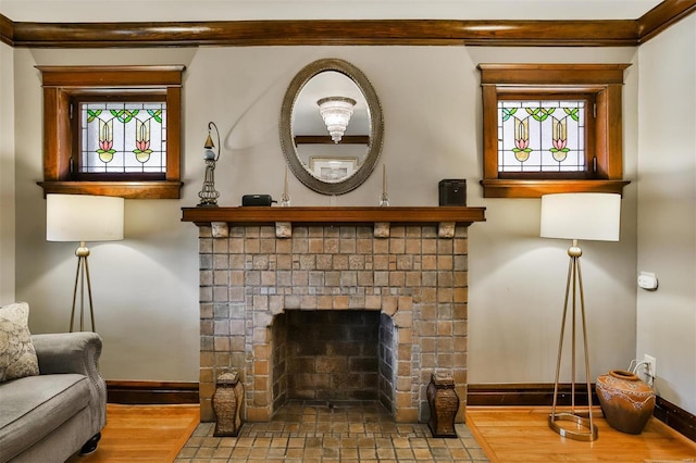 interior details with a brick fireplace, baseboards, and wood finished floors