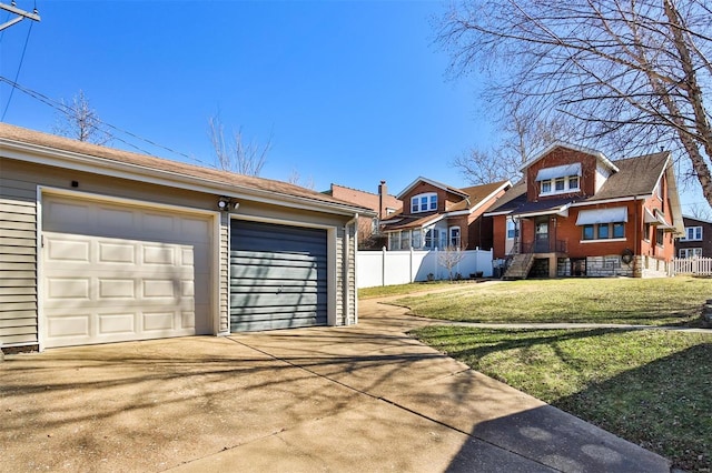 view of front of home with a garage, driveway, fence, an outdoor structure, and a front lawn