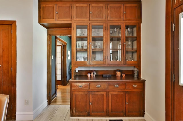 bar featuring light wood-type flooring and baseboards