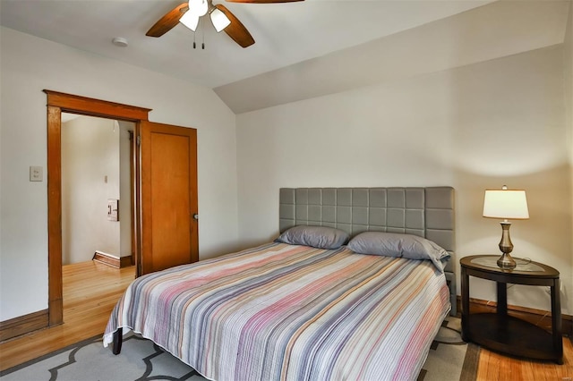 bedroom featuring lofted ceiling, ceiling fan, baseboards, and wood finished floors