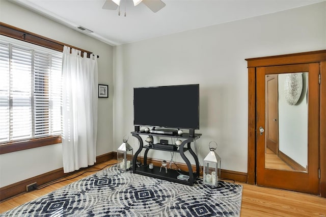 interior space featuring a ceiling fan, visible vents, light wood-style flooring, and baseboards