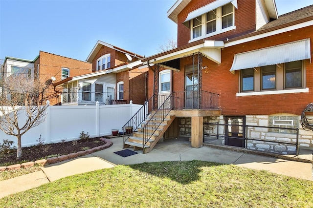 view of front of house with stone siding, fence, and brick siding