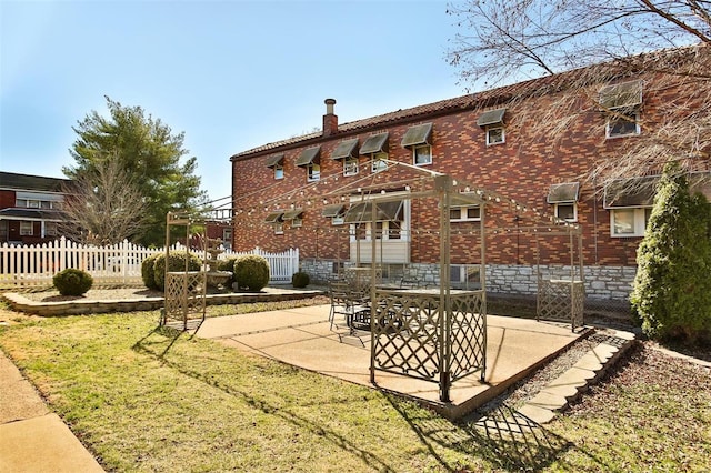 exterior space with a patio, brick siding, and fence