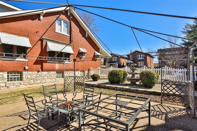 view of patio featuring fence and a residential view