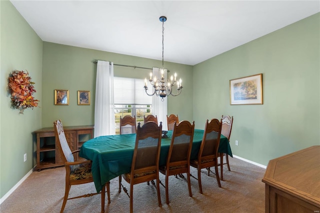 dining space with light carpet, a notable chandelier, and baseboards