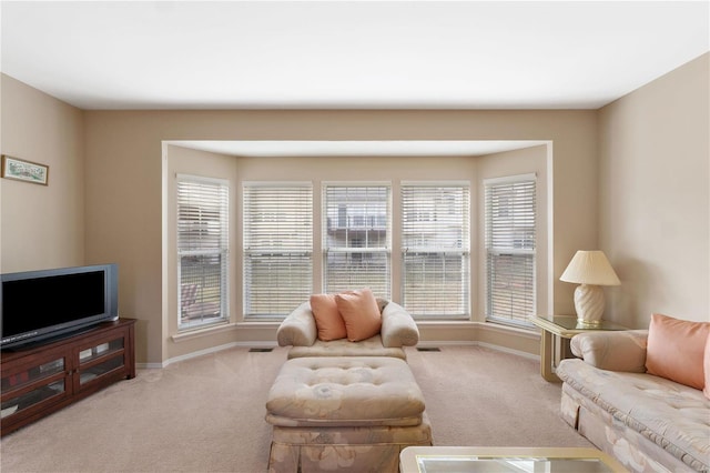 carpeted living area with baseboards